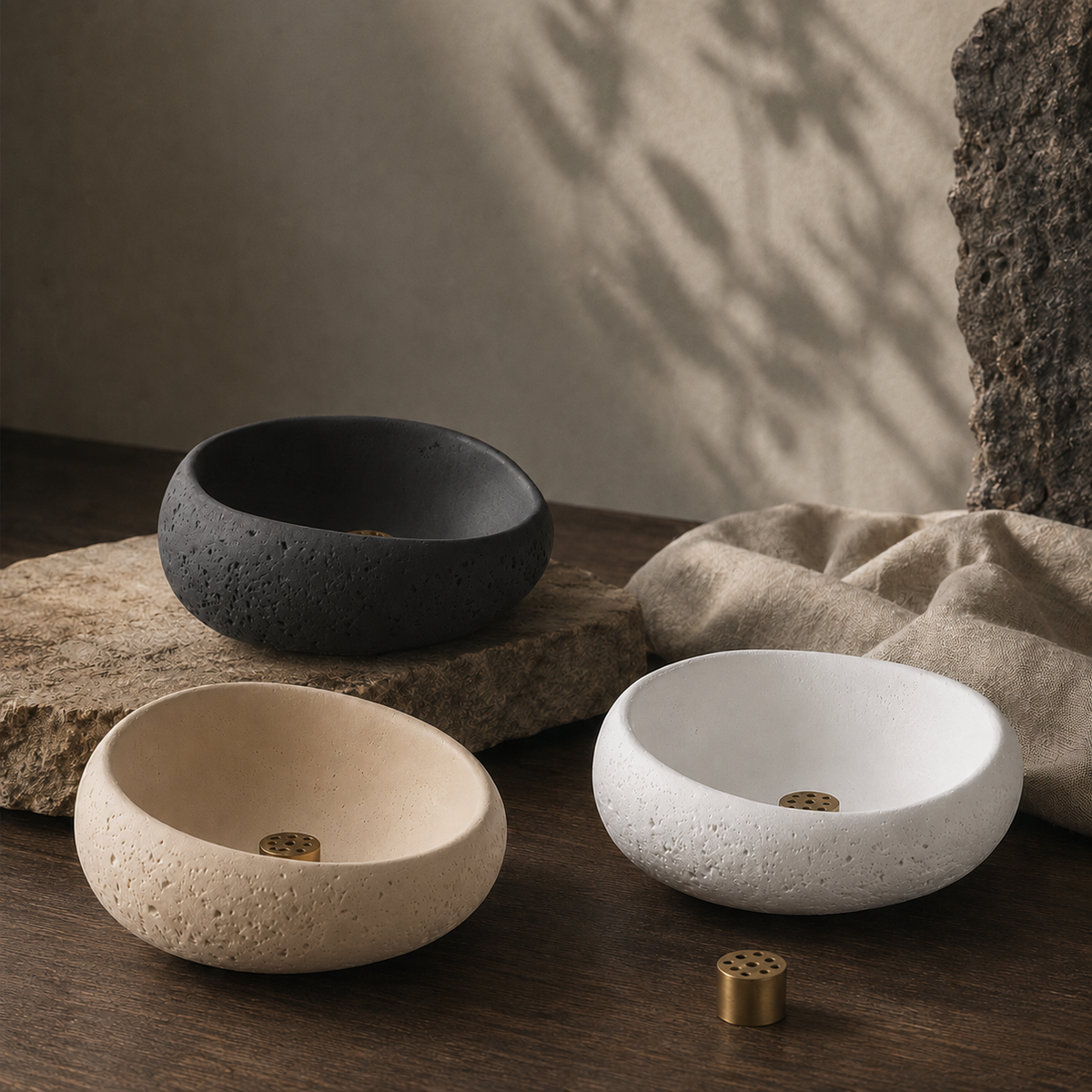 Trois porte-encens en céramique texturée dans les coloris noir mat, sable chaud et blanc ivoire